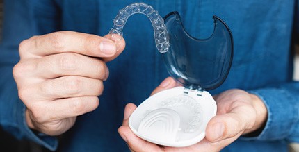 A hand holding an Invisalign aligner