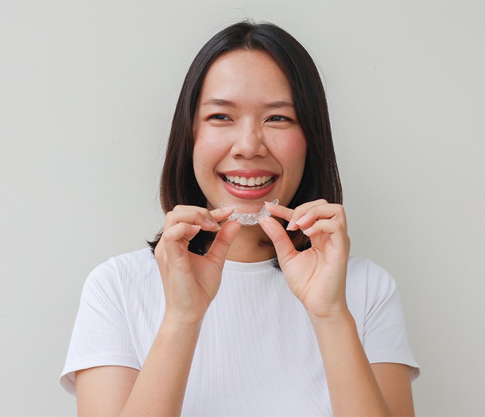 A teenager holding Invisalign aligners