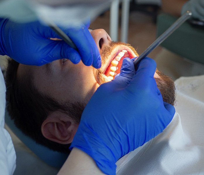 Dentist applying meds to man’s gums