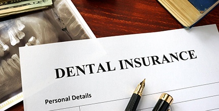 Dental insurance form on a crowded desk