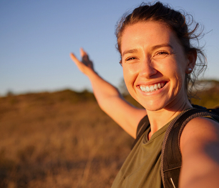 Woman smiling while backpacking 