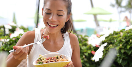 Woman smiling while eating lunch outside 