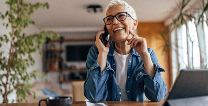 Woman smiling while talking on the phone at home