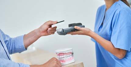 patient paying for porcelain veneers in Millersville
