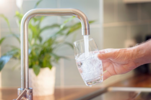 Close up of hand filling glass with tap water